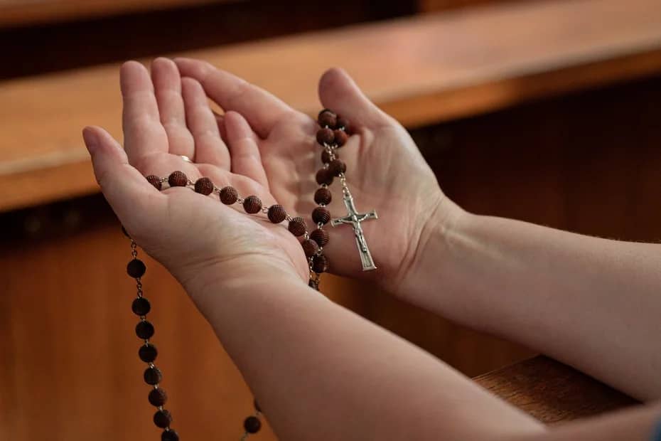 The Power of the Holy Rosary: Why You Should Pray It Daily. Close up shot of a person praying the Rosary